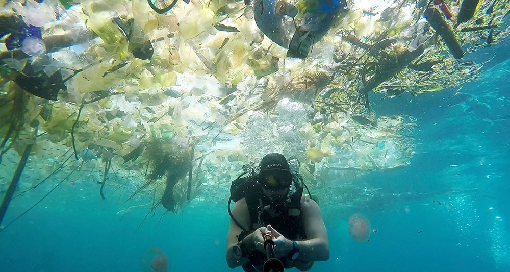 plongeur qui découvre les déchets plastiques dans l'océan